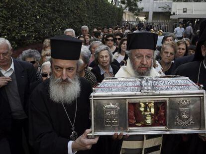 Varios popes transportan las reliquias al hospital.