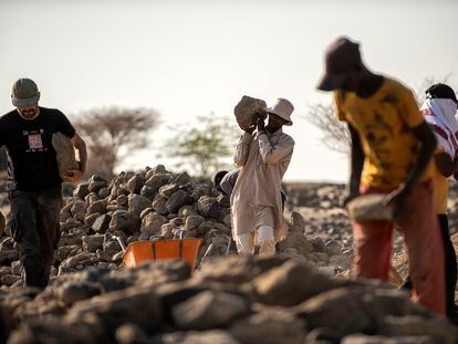 Parte del equipo cubre la excavación para continuar con ella en la próxima campaña. En la fotografía, Jorge De Torres, coordinador del proyecto, junto a Abdo, uno de los trabajadores yibutíes, transportan piedras para rellenarlas posteriormente con arena.