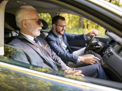 Dos ejecutivos viajan juntos en automóvil a una reunión de negocios.