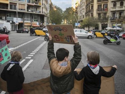 Niños de diferentes escuelas de Barcelona cortan el tráfico en protesta contra la contaminación, este viernes.