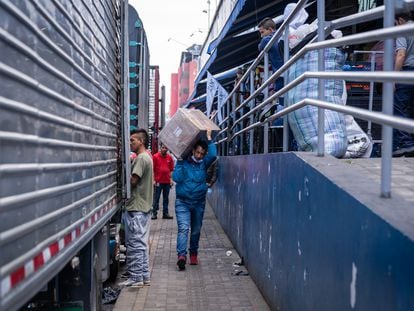 Cotero de San Victorino descarga un camión con mercancía para poder surtir toda la demanda del comercio durante el Madrugón, en Bogotá, el 21 de diciembre de 2022.