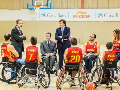 El presidente de CaixaBank, Jordi Gual (izquierda), el presidente de la FEDDF, José Alberto Álvarez (centro), y el del Consejo Superior de Deportes, José Ramón Lete (derecha), charlan con jugadores de las selecciones femenina y masculina de baloncesto en silla.