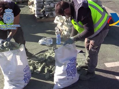 Dos agentes trasladan las bolsas de heroína que encontraron dentro de sacos de cemento, en noviembre de 2017.