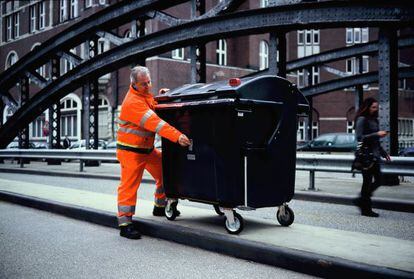El empleado de recogida de basuras de Hamburgo, Hans-Dieter Braatz realiza una fotografía con el contenedor 'tuneado' en cámara de fotos.