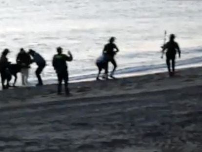 Los guardias civiles devuelven a inmigrantes a Marruecos en la playa deTarajal.