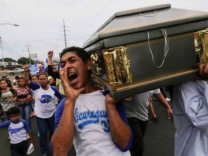TOPSHOT - CORRECTION - Friends and relatives carry the coffin containing the body of the student Gerald Velazquez, shot dead during clashes with riot police in a church near the National Autonomous University of Nicaragua (UNAN) in Managua,on July 16, 2018. 
 
 Government forces in Nicaragua on Saturday shot dead two young men at a protest site in a church, the clergy said, on the third day of nationwide demonstrations against President Daniel Ortega, a former revolutionary hero now accused of authoritarianism. / AFP PHOTO / INTI OCON / “The erroneous mention[s] appearing in the metadata of this photo by INTI OCON has been modified in AFP systems in the following manner: [Velazquez] instead of [Vazquez]. Please immediately remove the erroneous mention[s] from all your online services and delete it (them) from your servers. If you have been authorized by AFP to distribute it (them) to third parties, please ensure that the same actions are carried out by them. Failure to promptly comply with these instructions will entail liability on your part for any continued or post notification usage. Therefore we thank you very much for all your attention and prompt action. We are sorry for the inconvenience this notification may cause and remain at your disposal for any further information you may require.”