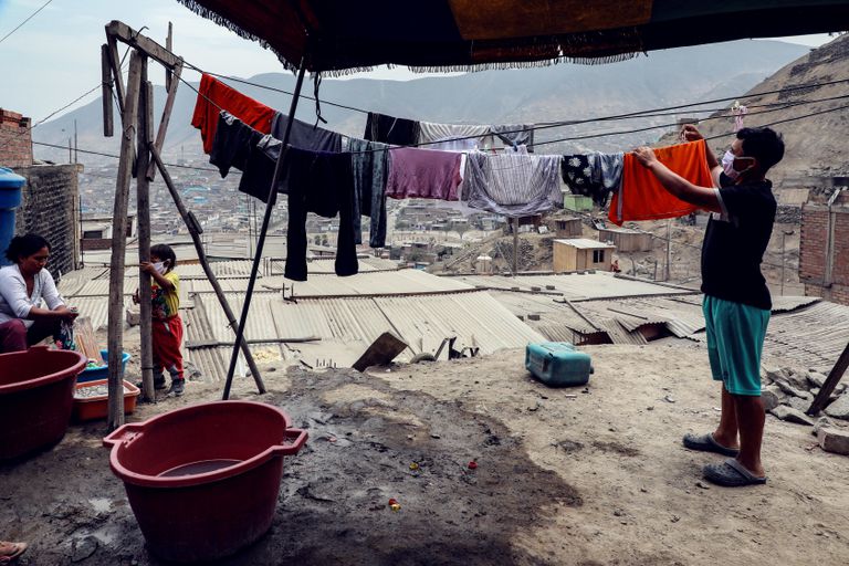 Habitantes del barrio Los Jazmines, en Lima (Perú), extienden sus ropas recién lavadas.
