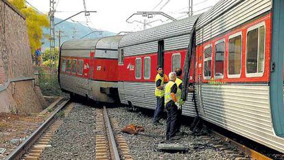Tres operarios comprueban el estado de los vagones del Talgo que se salieron de la vía en Alcover (Tarragona).