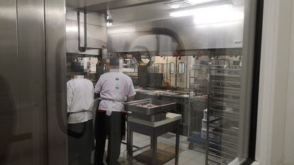Dos empleados en las cocinas centrales de Ifema, en Madrid, desde donde la empresa Eurest prepara la comida del Hospital de Emergencias Isabel Zendal.