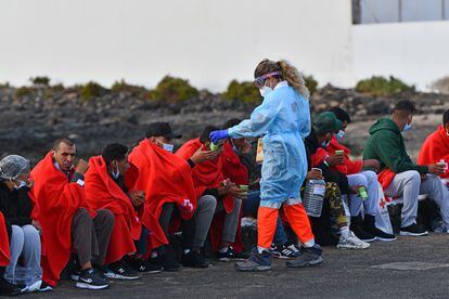 Un voluntario de la Cruz Roja atiende a un grupo de migrantes el pasado 7 de septiembre, en Las Caletas, Islas Canarias.