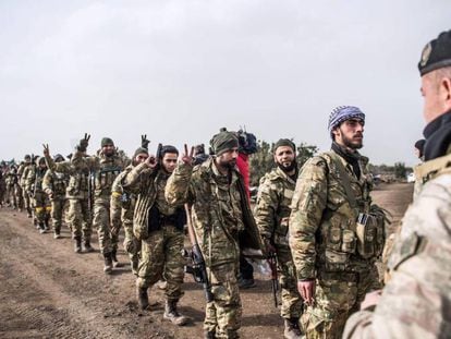 Soldados de la oposición a Bachar el Asad caminan frente a tropas turcas cerca de Hassa el 22 de enero de 2018, para combatir a los kurdos de Siria.