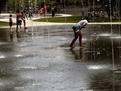 Gente mojandose en los chorros en Madrid Río, ante la ola de calor.