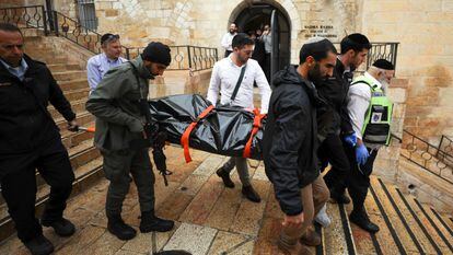 Personal de seguridad israelí retira uno de los cadáveres tras el atentado de este domingo en la Ciudad Vieja de Jerusalén.
