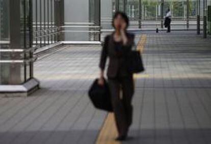 Una viandante habla por el m&oacute;vil en una calle de Tokio