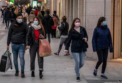 Varias personas con bolsas de diferentes comercios caminan por la calle Preciados, en Madrid, el pasado diciembre.