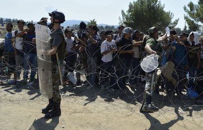 Inmigrantes esperan en el paso fronterizo de Macedonia y Grecia cerca de Gevgelijam, el 28 de agosto de 2015.