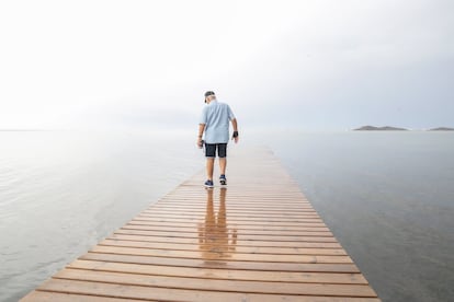 Ángel Pérez, vecino de Los Urrutias, observa el agua sucia del mar Menor desde un embarcadero próximo a su casa.