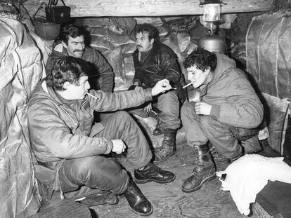 Soldados argentinos dialogan y comparten cigarrillos en una de las trincheras de las Islas Malvinas. En las planchas de fotos que llegaban a las oficinas de la agencia en Buenos Aires se marcaba en rojo y negro las fotos de soldados que no podían llegar a la prensa.