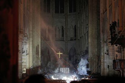 Interior de la catedral de Notre-Dame després de l'incendi. L'altar està envoltat de trossos de fusta carbonitzada i encara fumejant.