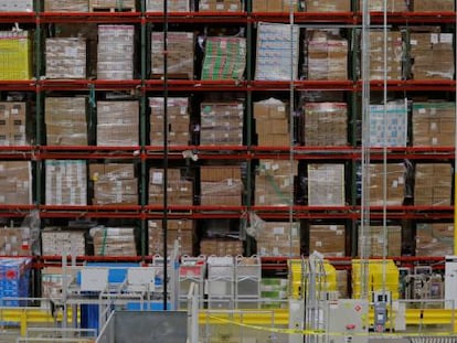 Cajas apliladas de productos en un almacén de Amazon.