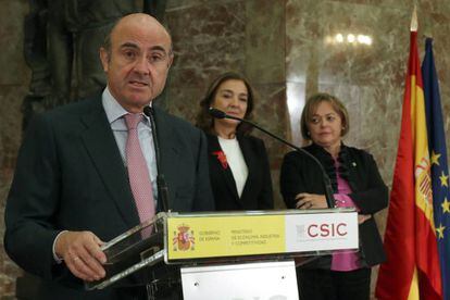 El ministro de Econom&iacute;a, Industria y Competitividad, Luis de Guindos, durante su intervenci&oacute;n en el acto de toma posesi&oacute;n de la nueva presidenta del Consejo Superior de Investigaciones Cient&iacute;ficas (CSIC), Rosa Men&eacute;ndez (d), junto a la secretaria de Estado de I+D+i, Carmen Vela. 