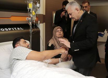 El primer ministro turco, Binali Yildirim, saluda a un herido del ataque en un hospital de Estambul.