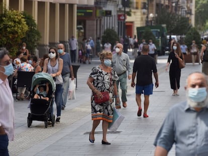 Varias personas con mascarilla caminan por las calles de Huesca este martes.