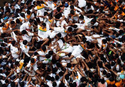 Un grupo de devotos caen mientras intentan formar una pirámide humana durante las celebraciones de Janmashtami, en Bombay (India).