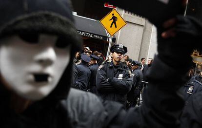 Un agente de policía observa a los manifestantes de 'Ocupa Wall Street' durante las protestas en el barrio financiero de Nueva York en el llamado 'Día de la Acción'.