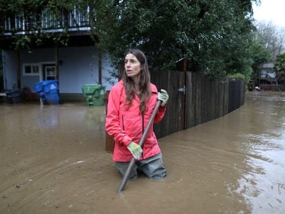 Melissa Foley clears debris and helps in her neighborhood as the San Lorenzo River rises with emergency evacuation orders in Felton Grove, California, U.S., January 14, 2023.  REUTERS/David Swanson     TPX IMAGES OF THE DAY