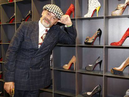 Christian Louboutin posa delante de algunas de sus creaciones.