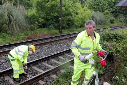 Dos operarios de Adif limpian las vías del tren en el lugar del impacto con las dos fallecidas.