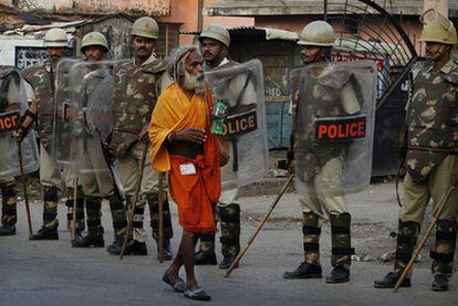 Un gurú camina, junto a varios agentes de policía, por las calles de la ciudad de Ayodhya.