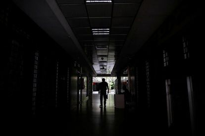 Un hombre camina por un pasillo a oscuras de un edificio en Caracas (Venezuela), este martes. El líder chavista Maduro ordenó desde el lunes el cese de las actividades laborales y educativas que se mantendrá este miércoles sin que hasta ahora haya certezas sobre el retorno pleno de la electricidad.
