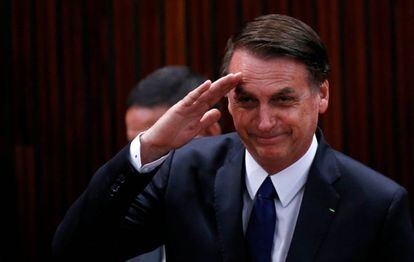 Bolsonaro saluda antes de recibir el diploma del Tribunal Electoral.