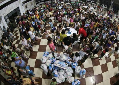 Víctimas del tifón se refugian en un gimnasio en el que se reparten artículos de primera necesidad en la ciudad de San José, provincia de Nueva Écija, al norte de Manila.