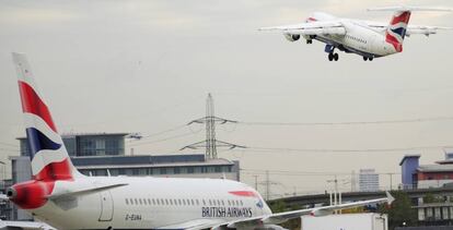 Un avión de British Airways -una de las empresas denunciadas por discriminación- espera para despegar, mientras que el otro ya ha despegado.