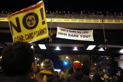 Dos personas despliegan una pancarta desde el puente de Eduardo Dato de Madrid: "solo quedan 8 años hasta los 1,5 grados. ¿CÓMO TE ATREVES?", reza uno de ellos.