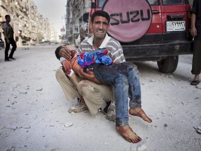 Un padre sirio llora con su hijo muerto en brazos en frente del hospital de Dar al Shifa, en Alepo.