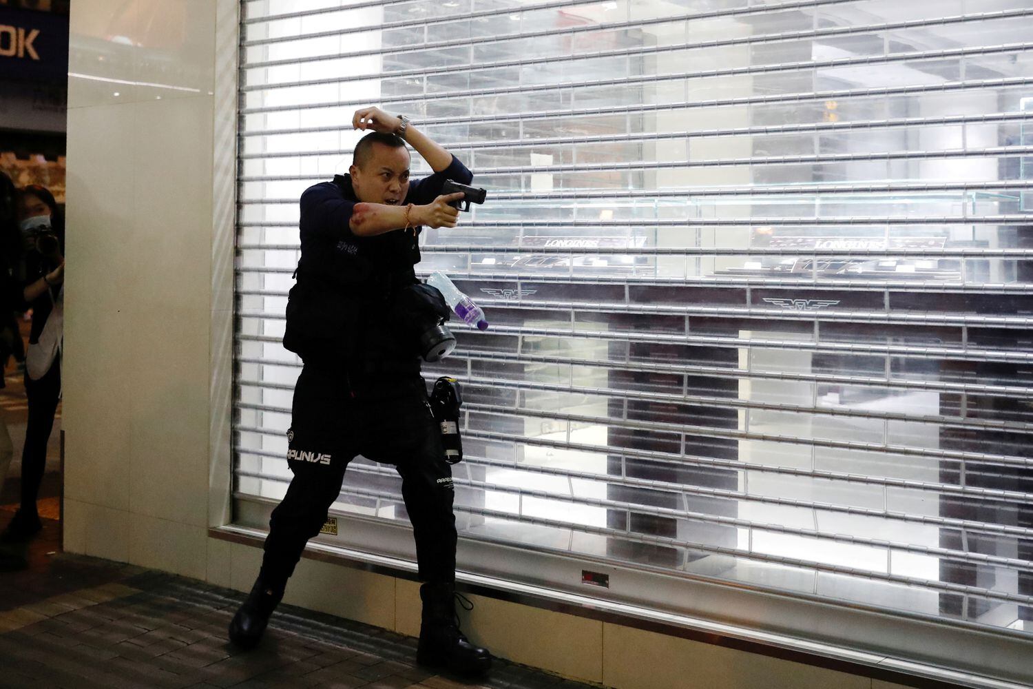 Un policía apunta con su arma a manifestantes en Hong Kong, el pasado 29 de febrero.
