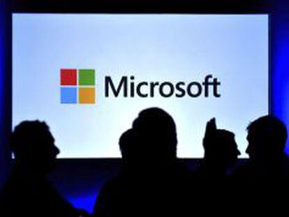 Varias personas ante una pantalla con el logo de Microsoft.