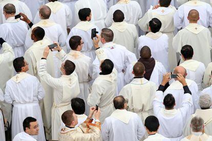 Sacerdotes sacan fotos con sus móviles durante la misa oficiada por el papa Francisco antes de la apertura de la Puerta Santa.