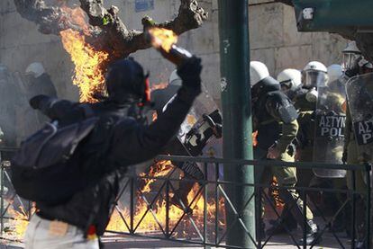 Un joven lanza un cóctel molotov, en la protesta de ayer en la plaza de Sintagma de Atenas.