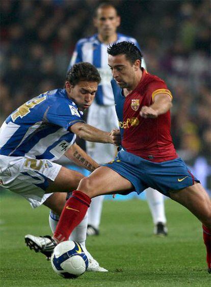 Xavi disputa la pelota con Lolo.