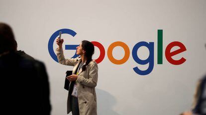 Una usuaria consulta su móvil junto al logotipo de Google.