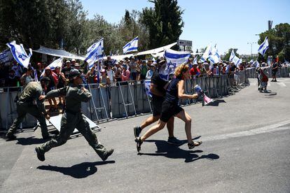 Demonstrators run after crossing a police line at the entrance to the Knesset, Israel's parliament, during a demonstration against judicial reform by Israeli Prime Minister Benjamin Netanyahu and his national coalition government in Jerusalem on Monday.