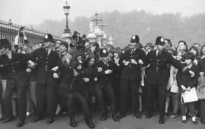 La policía trata de contener a los fans de The Beatles a las puertas de Buckingham Palace, donde fueron condecorados con la medalla del Imperio británico en octubre de 1965.