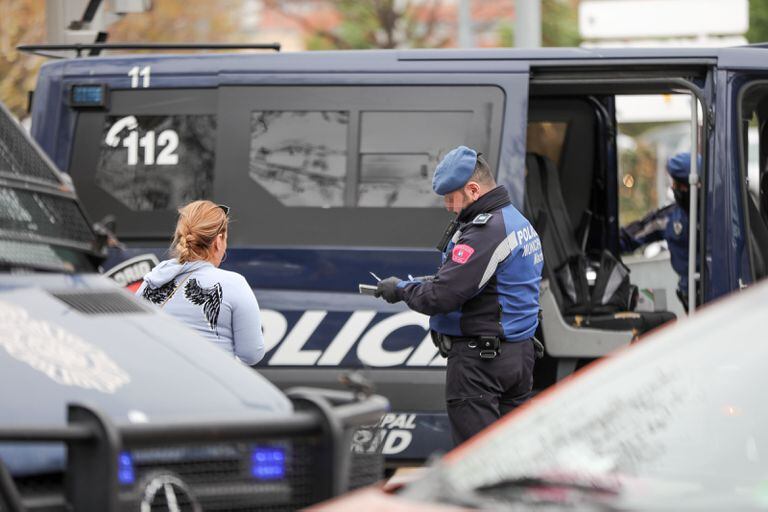 Un agente de la Policía Municipal multa a una mujer por un viaje no justificado.