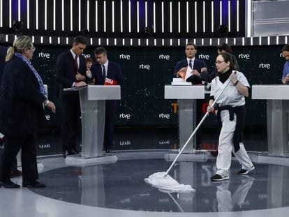 Una mujer de la limpieza abrillanta el suelo mientras los candidatos se preparan para el debate.