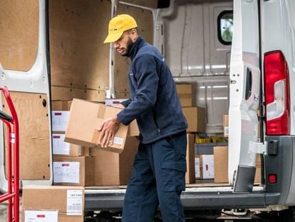 Un repartidor baja cajas de una furgoneta para realizar las entregas a los clientes.